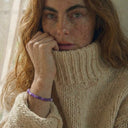A woman wearing an amethyst gemstone bracelet