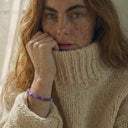 A woman wearing an amethyst gemstone bracelet