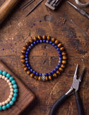 A Tiger Eye and Deep Blue bracelet surrounded by tools in a workshop