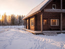 A winter landscape featuring a rustic, dark-wood log cabin heavily surrounded by snow in Inari, Finland.