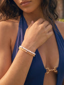 Woman wearing a blue bikini with Citrine and Snow beaded bracelets