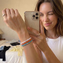 A woman taking a mirror selfie with her Baxter&Baxter bracelets