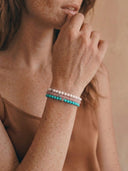 A close-up of a woman wearing a stack of 4mm bracelets