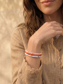 A close-up of a person wearing a stack of 4mm beaded bracelets.