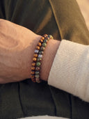 A close-up of a person wearing a stack of 6mm beaded bracelets.