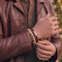 A close-up of a person wearing a Chocolate Brown Woven Leather Bracelet