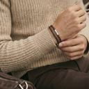 A man wearing a brown woven leather bracelet