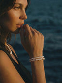 Woman wearing a stack of pearl bracelets and a pearl necklace