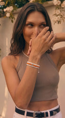 A woman wearing gemstone and pearl bracelets and a pearl necklace