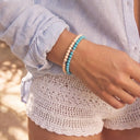 A woman wearing Ivory and Turquoise bracelets at the beach