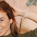 Woman wearing a stack of gemstone bracelets