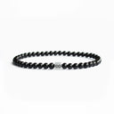 Black onyx beaded bracelet with a brushed silver logo bead
