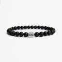 Matte black onyx beaded bracelet with a brushed silver logo bead